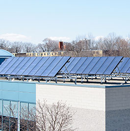 solar panels on top of a white and glass building
