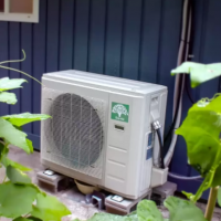 Heat pump in garden by house