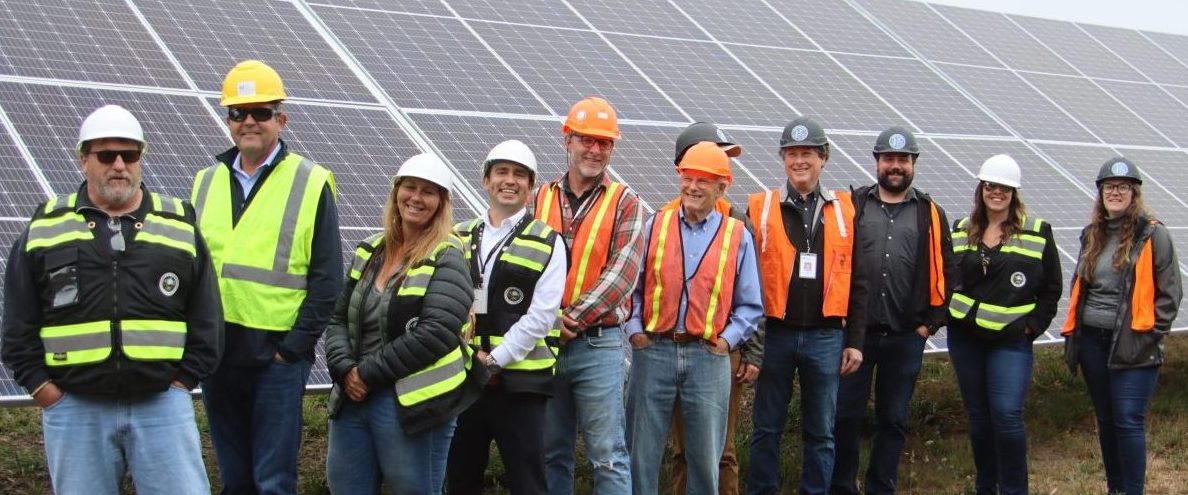 Local leaders standing in front of a solar array at the Redwood Coast Airport Microgrid
