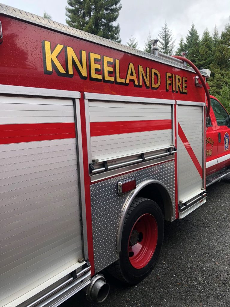 side of fire truck with "Kneeland Fire" written on it