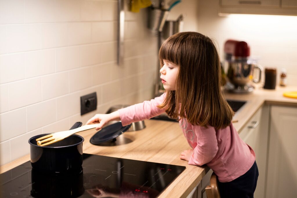 Little girl cooking on an induction cooktop